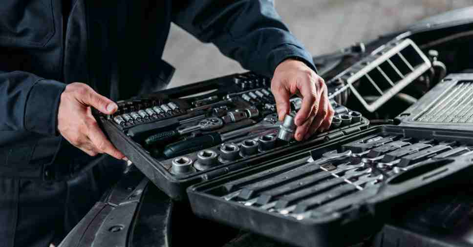 Mecânico organiza estojo completo de ferramentas para o controle de peças da oficina.